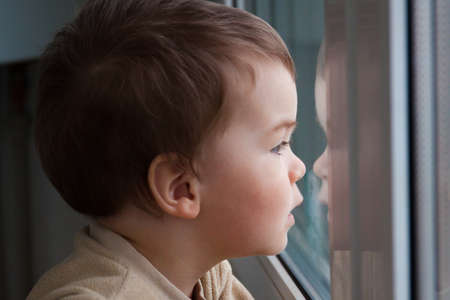 The child looks out the window. Expectation.の写真素材