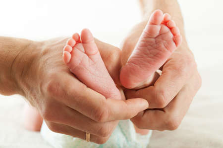 Newborn baby. Concept of child care, feeling safe, parent love.