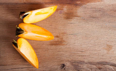 Fresh ripe persimmon close up on wood desk. Nature backgroundの写真素材
