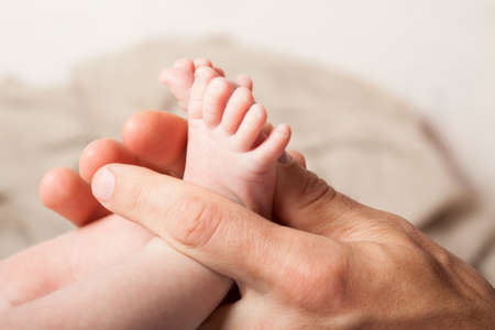 Infant leg in parent hand. Love for the child