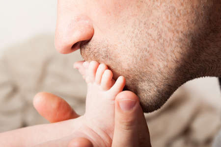 Father kisses the baby's leg. Love for the child