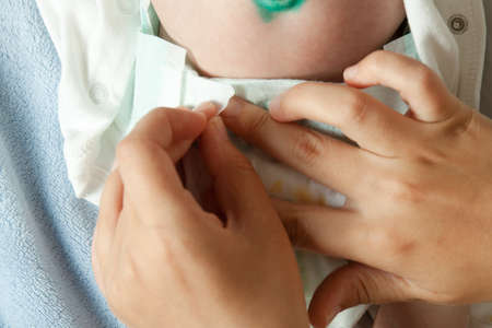Mom changes the baby's diaper. Baby care