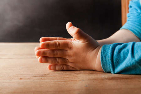 The hands of the child are folded for prayer. Religion conceptの写真素材