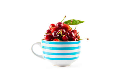 Cherry and strawberry in bowl close up isolated on white backgroundの写真素材