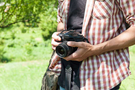 Man photograph with camera in hand on natureの写真素材