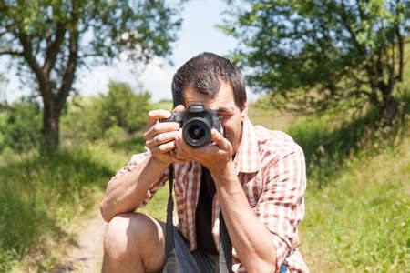 Man photograph with camera in hand on natureの写真素材