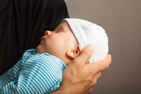 Infant on father hand. Family relationships. Paternal care. Father loveの写真素材