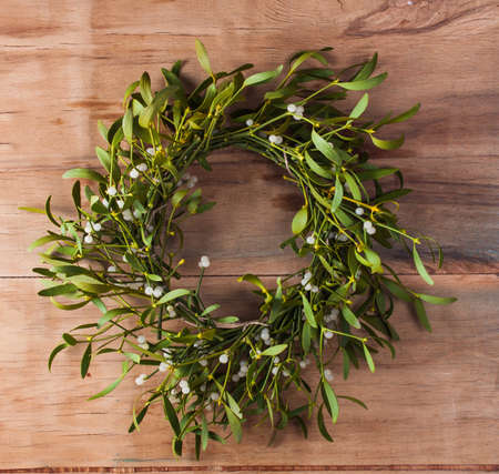 Christmas wreath with mistletoe on wood board. Christmas decoration.の写真素材