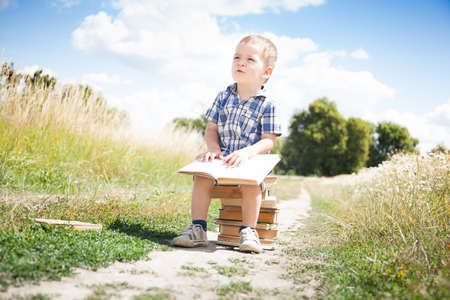 Fashion little boy with stack books outside. Back to schoolの写真素材