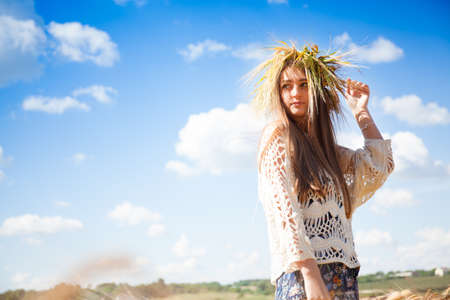 Fashion beautiful girl in the field with yellow spikelets on the sky backgroundの写真素材