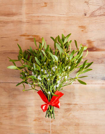Broom from green mistletoe on wood desk. Nature background. Christmas plantの写真素材