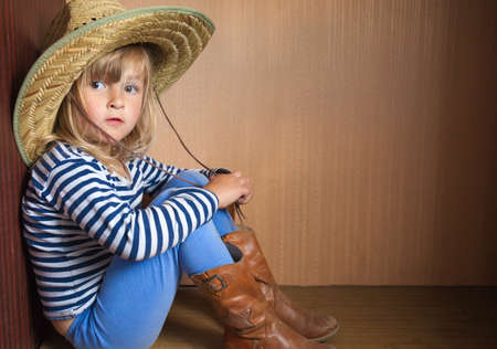 Happy little girl in hat on brick backgroundの写真素材