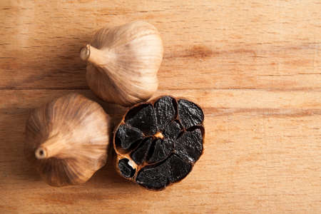Black garlic close up on wood desk.の写真素材