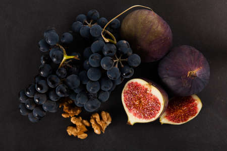 Fresh fig with grape on black background.の写真素材