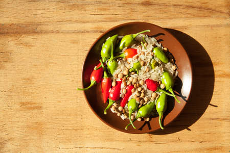 Raw lentils and rice with chilli pepper on wood.の写真素材