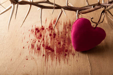 Crown of thorns with blood on wood deskの写真素材