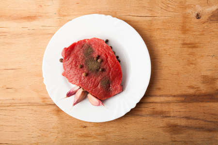 Fresh raw slice meat isolated on wooden backgroundの写真素材