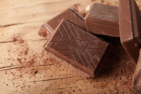 Piece of chocolate isolated on wooden background