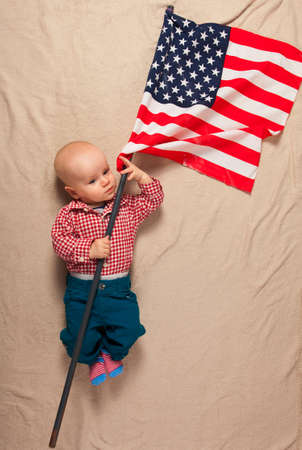 Child with american flag on bed.の写真素材