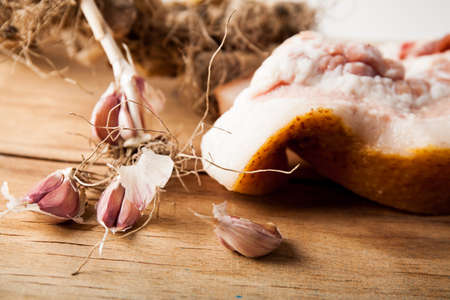 Pork fat with garlic on wood desk. Food ingredientsの写真素材