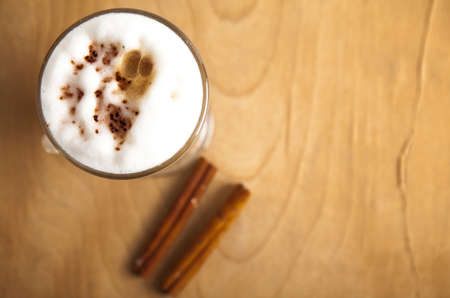 Coffee late with cinnamon on wood deskの写真素材