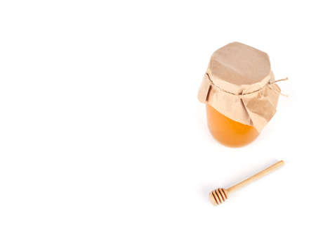 Honey in jar with wood spoon isolated on whiteの写真素材