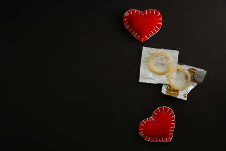 Open condom close up on black background