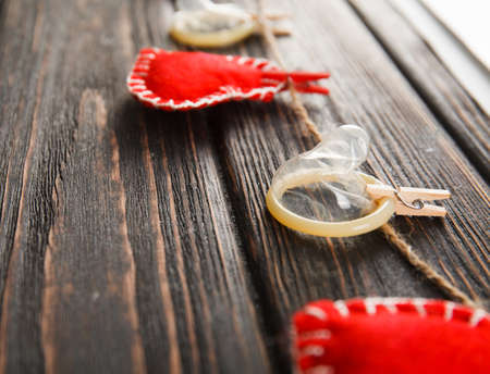 Open condom with heart close up on wood desk. Valentines dayの写真素材