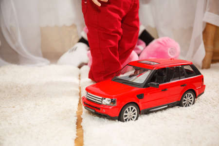 Child with toy red car. Happy birthday