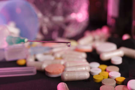 drop on a syringe needle and pills. Concept of medicalの写真素材