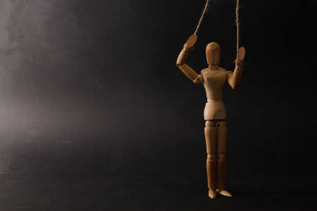 wooden puppet close up on black backgroundの写真素材