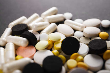 Pills close up on black background. Medical conceptの写真素材