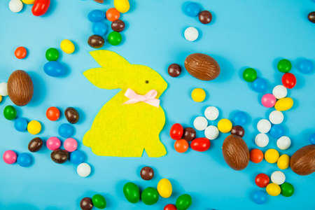 Chocolate eggs and glaze color candy on blue background. Happy easterの写真素材