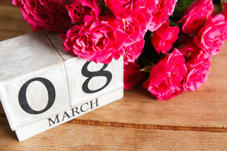Purple roses on wood desk. 8 march. Women's day