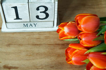 Tulip and block calendar on wood desk. Greeting card. Happy women's day