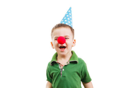 Boy in a festive cone and a clown's nose on white background. Fools dayの写真素材