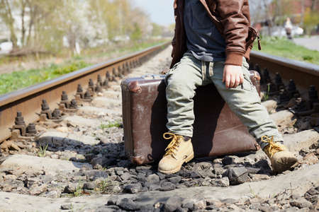 Little boy with suit case on railway out door. Travel concept