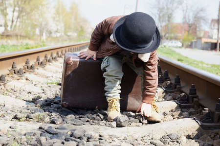 Little boy with suit case on railway out door. Travel conceptの写真素材