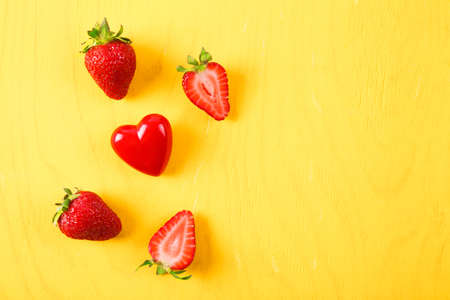 Ripe fresh strawberry on yellow background. Fruits close upの写真素材