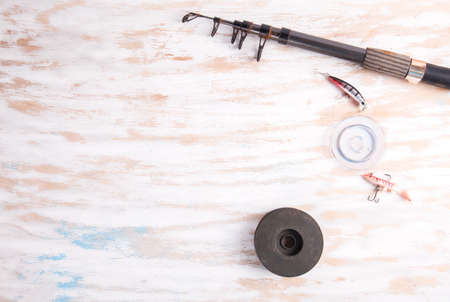 Fishing rod reel on wood background. Equipment close upの写真素材
