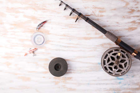 Fishing rod reel on wood background. Equipment close upの写真素材