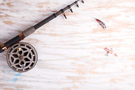 Fishing rod reel on wood background. Equipment close upの写真素材