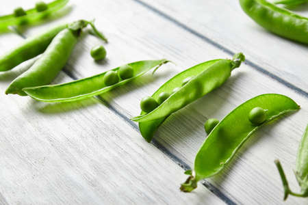 Fresh green pea close up on wood desk. Food ingredients. Top view