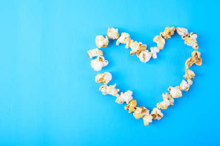 Paper cup with popcorn on color background. Fast food. Cinema concept. Top view.の写真素材