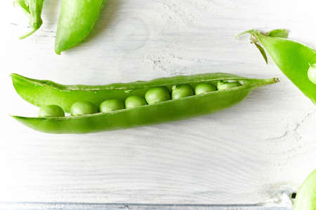 Fresh green pea close up on wood desk. Food ingredients. Top viewの写真素材