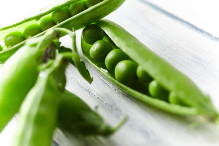 Fresh green pea close up on wood desk. Food ingredients. Top viewの写真素材
