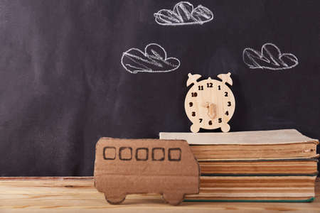 School bus and book from paper on black background. Education concept