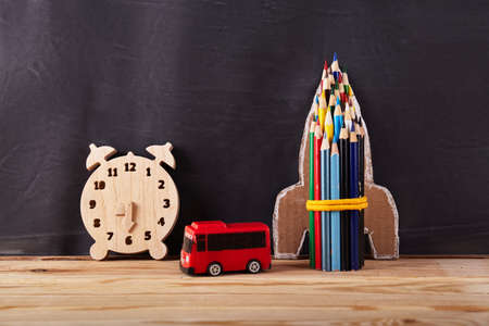 Rocket from pencil and clock, red bus on black background. Education conceptの写真素材