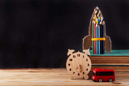 Back to school background. Stack of books and rocket from pencil