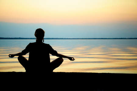 girl in yoga pose on the beach. Nature background. Sunset seaの写真素材